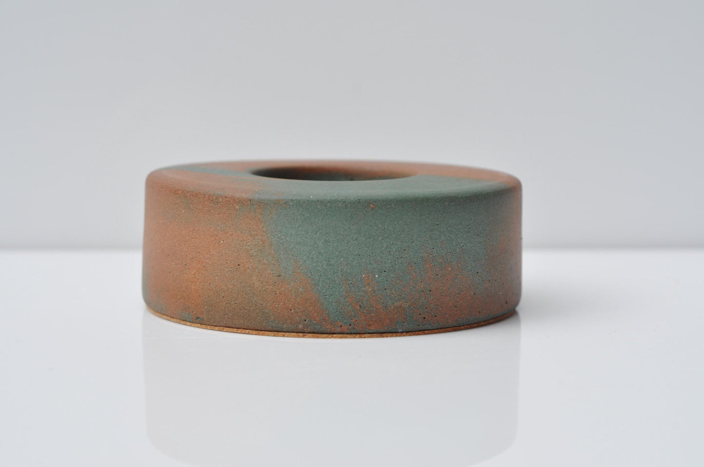 Cement ring candle holder with a textured surface on a white background