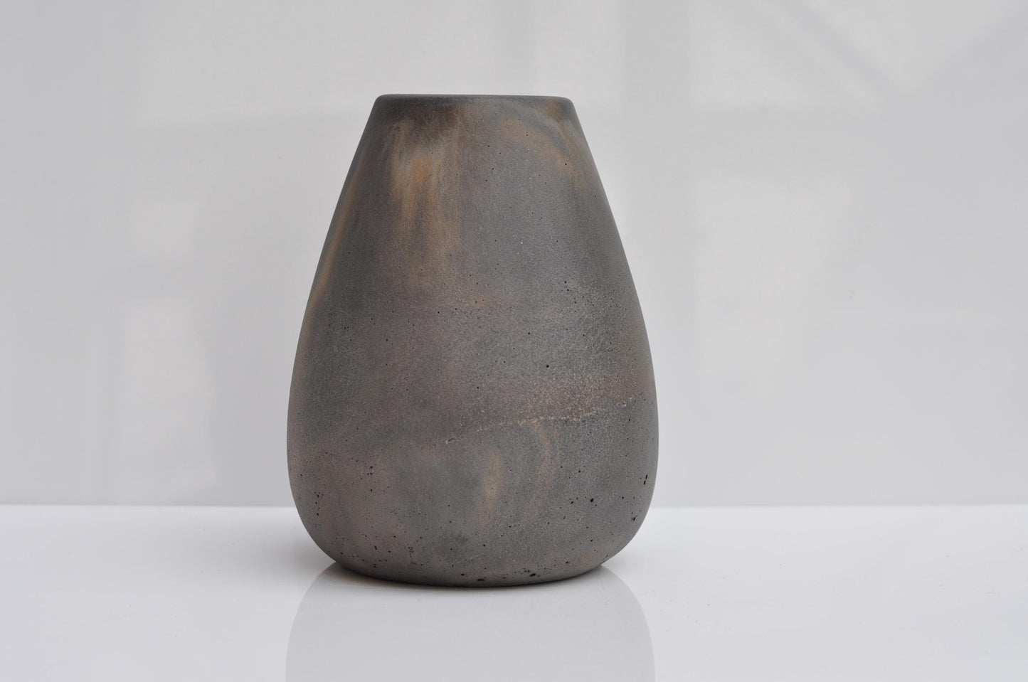 Dark gray concrete vase on a white background