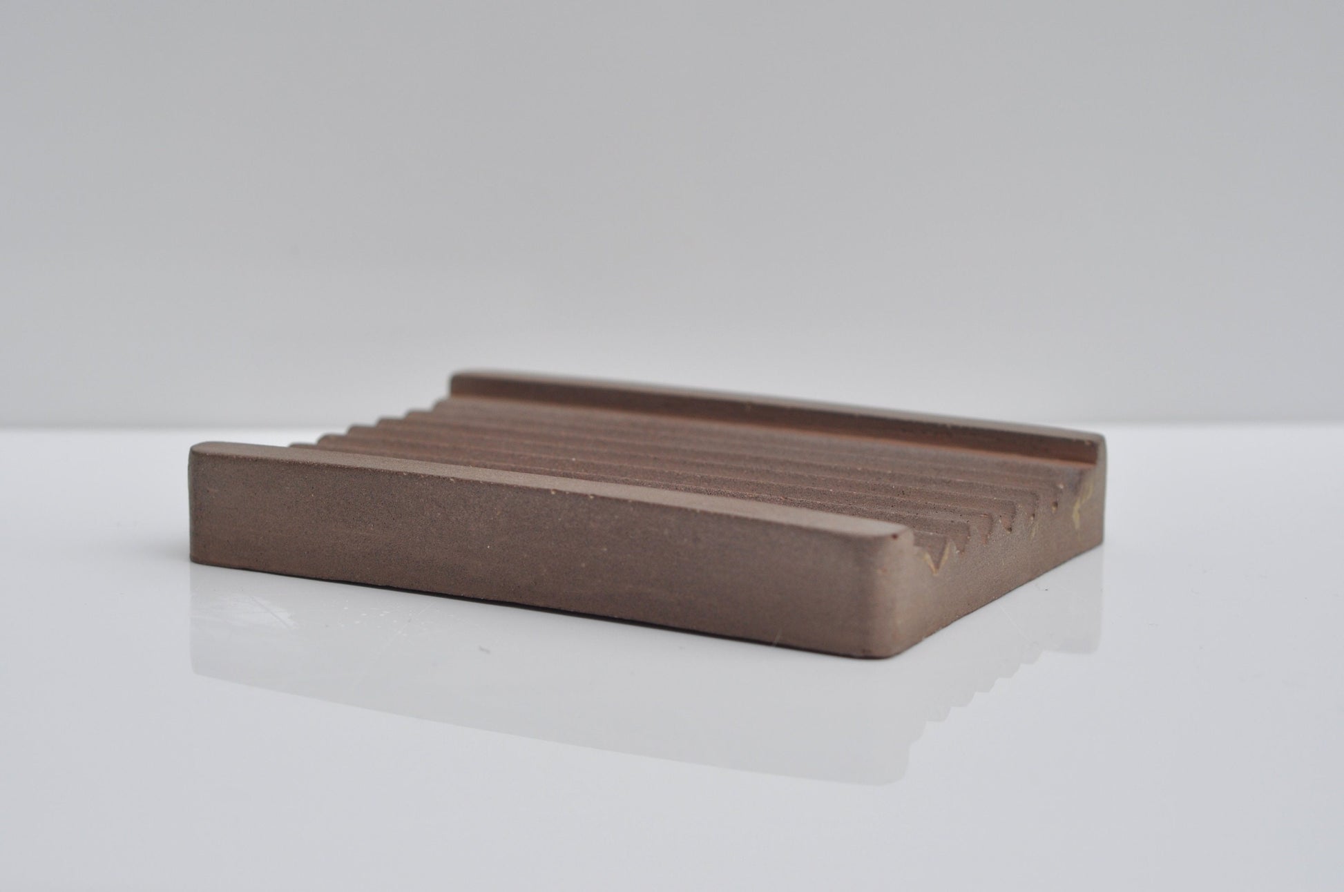 Concrete soap dish styled near side view