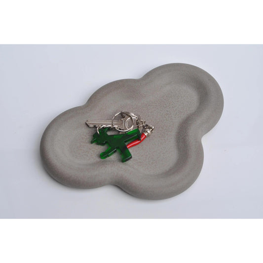 Keychain with green and red design on a cloud-shaped gray cement tray