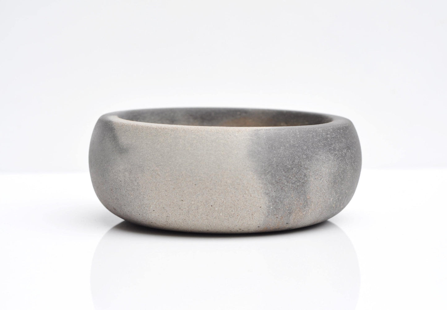 Round grey concrete key bowl on a hallway table
