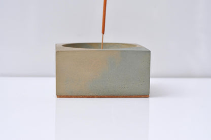 Concrete incense burner with smoke rising from incense