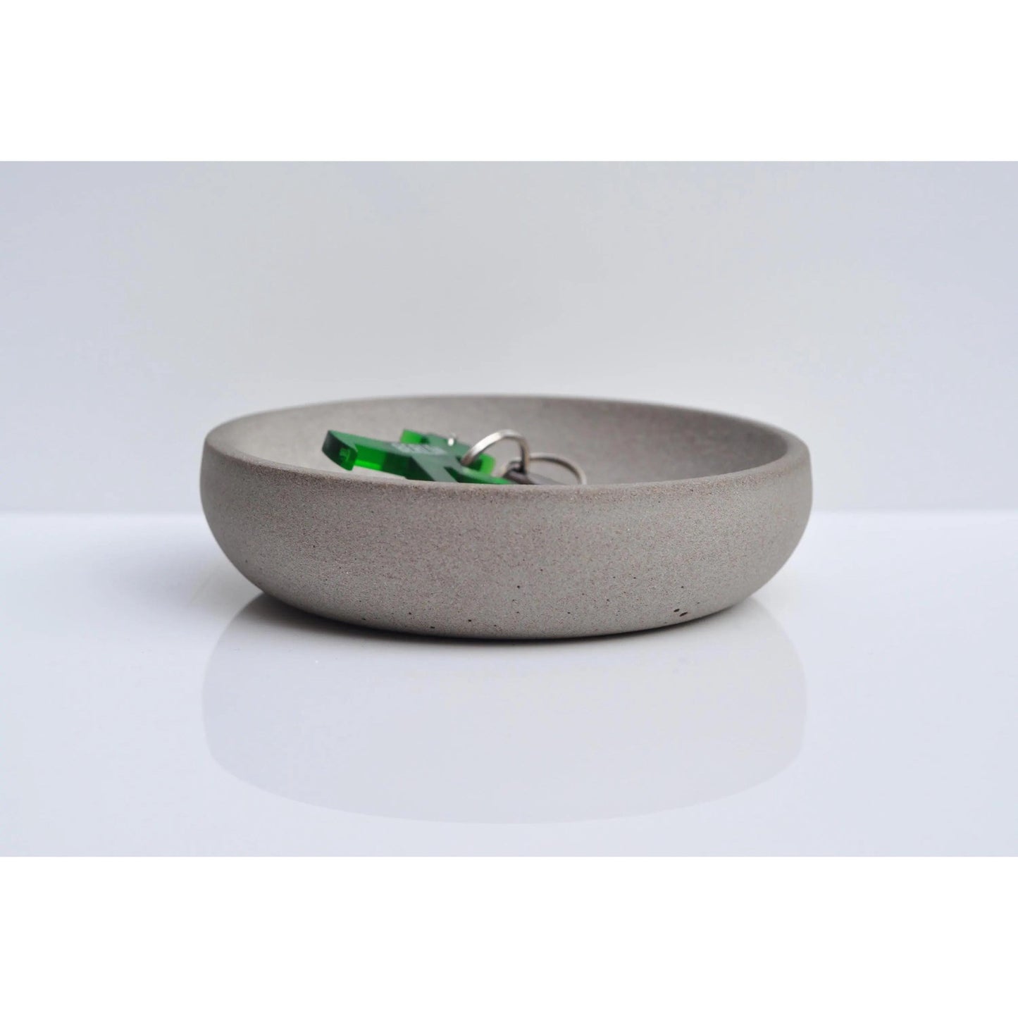 Handmade concrete key and coin bowl on entryway table