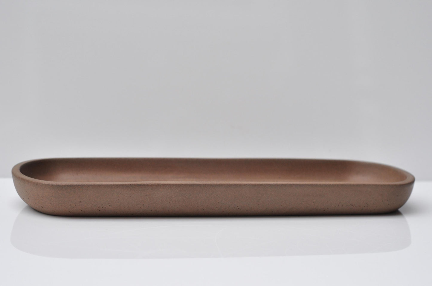 Modern orange concrete dish styled with decor items