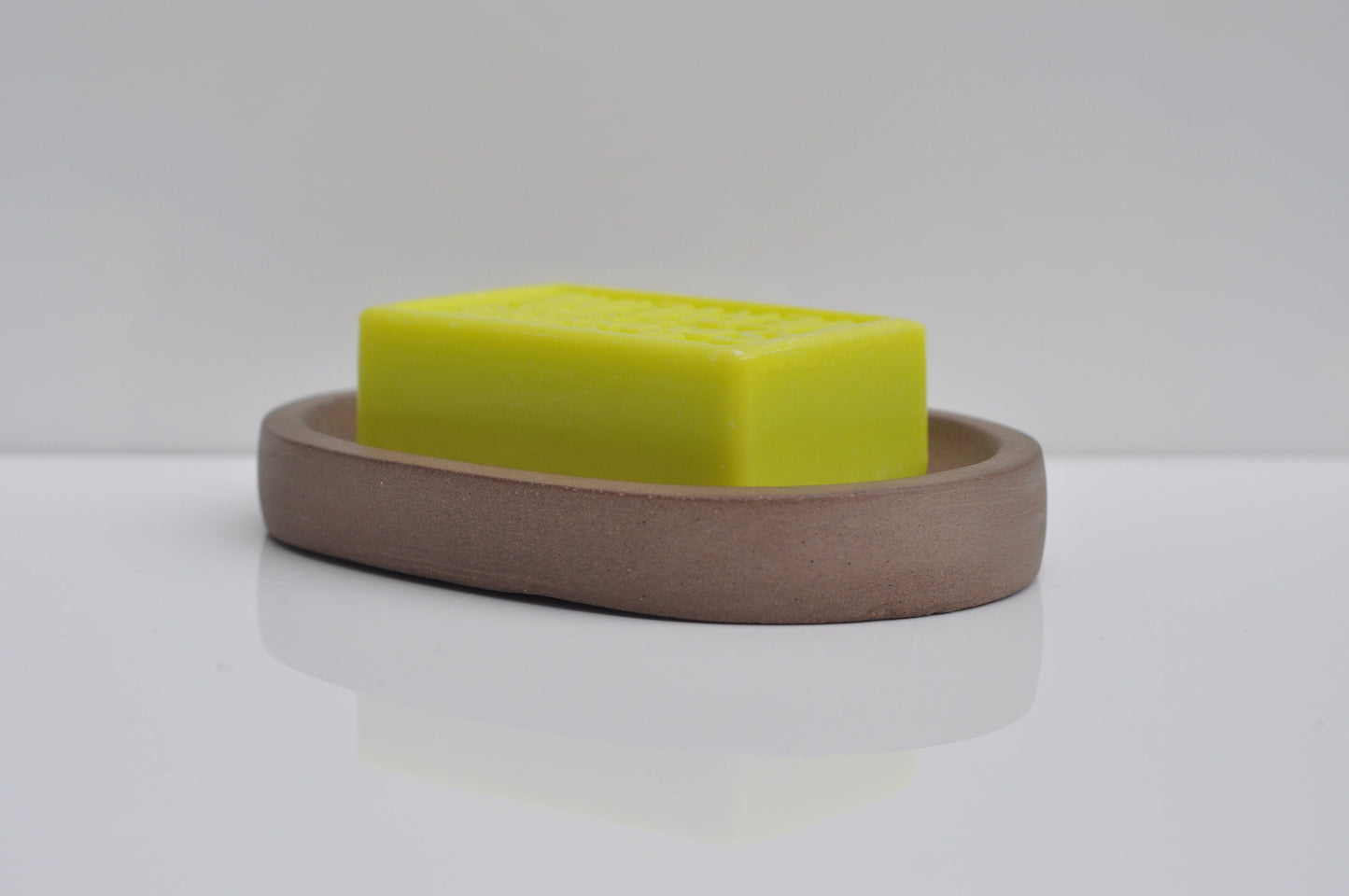 Concrete soap dish holding bar soap in bathroom
