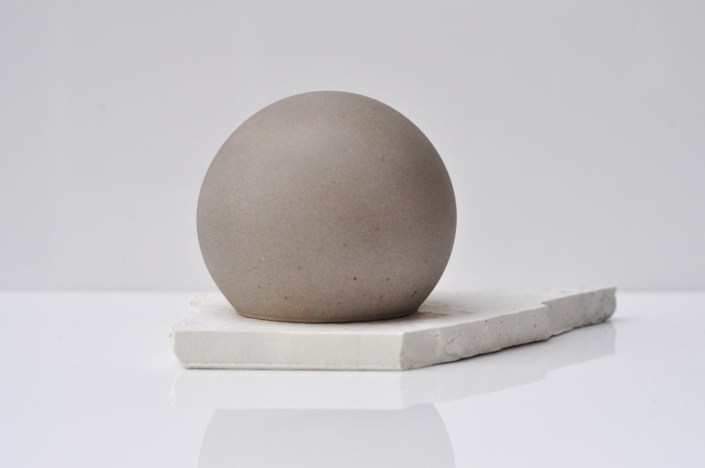Smooth grey concrete sphere decorative accent