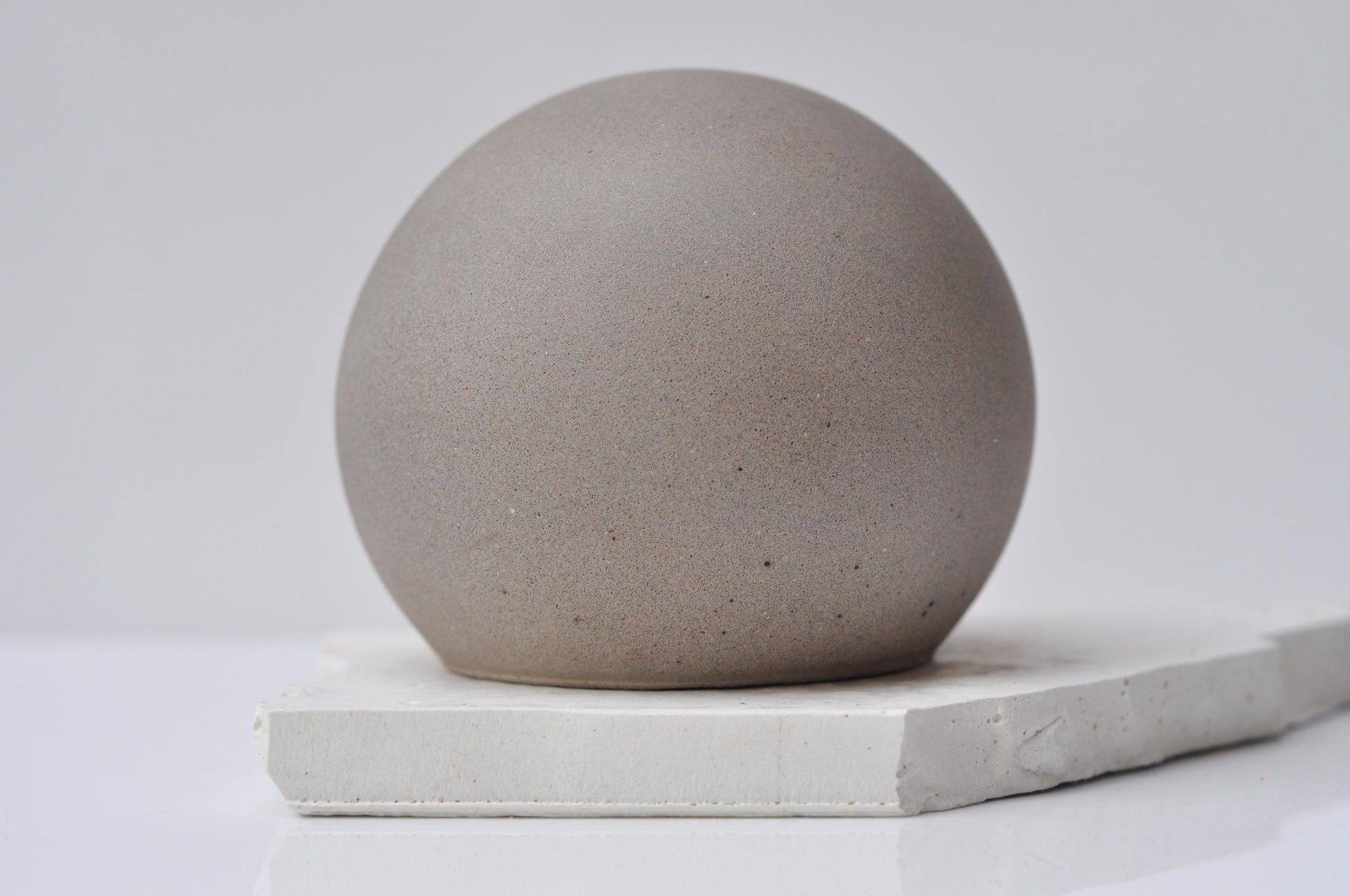 Concrete sphere paper weight styled on work desk