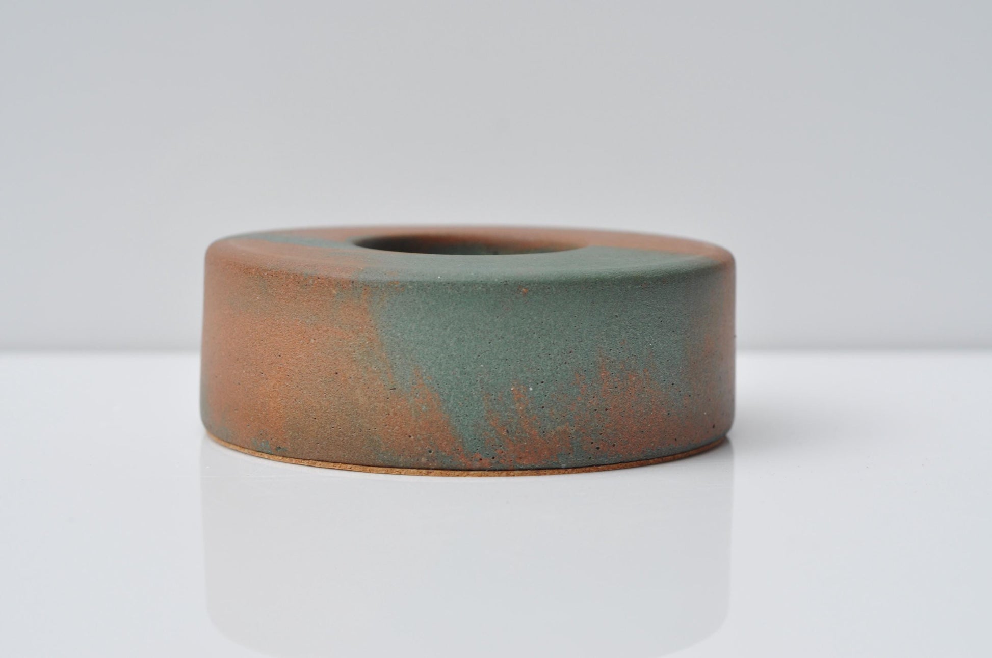Cement ring candle holder with a textured surface on a white background