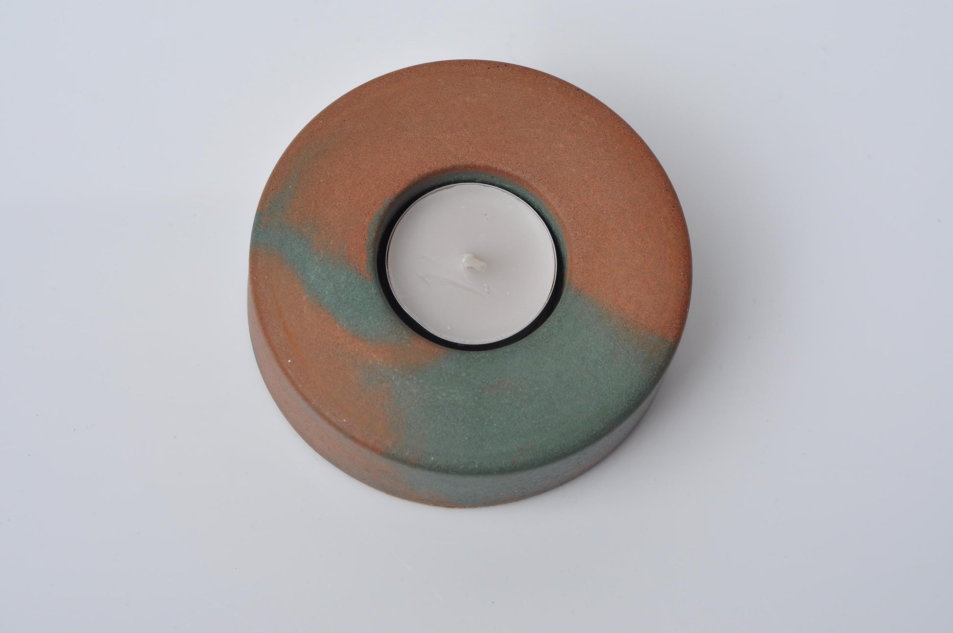 Round cement  candle holder with a marbled design on a white background