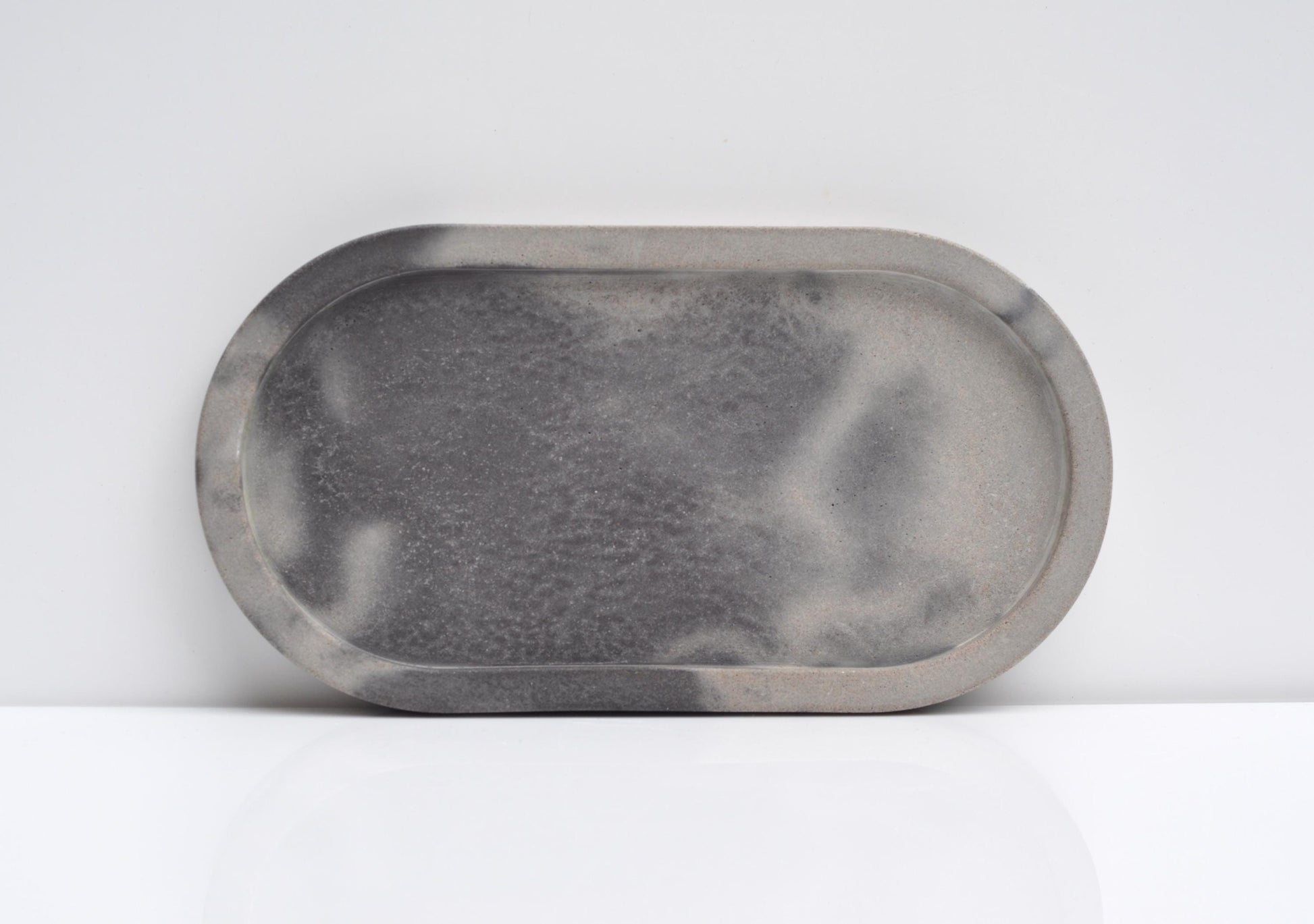 Studio shot of oval handmade concrete candle tray
