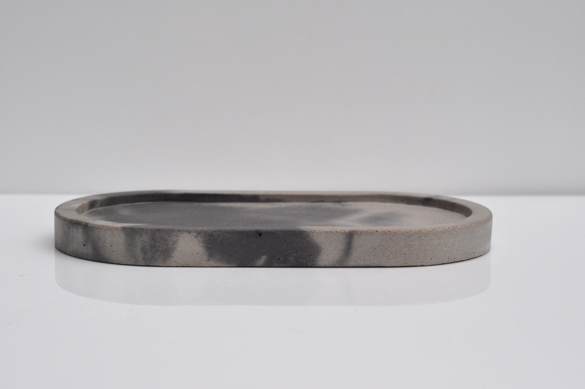 Minimalist oval concrete tray styled in modern home