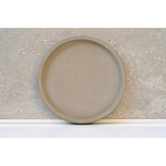 Round concrete plate with a textured surface on a concrete background