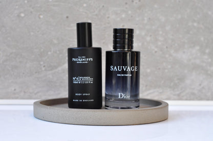 Two bottles of men's grooming products on a gray tray with a neutral background