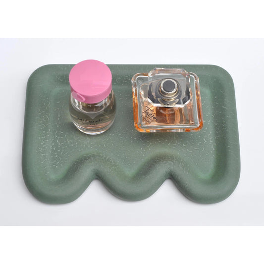 Handmade green concrete tray holding perfume bottles