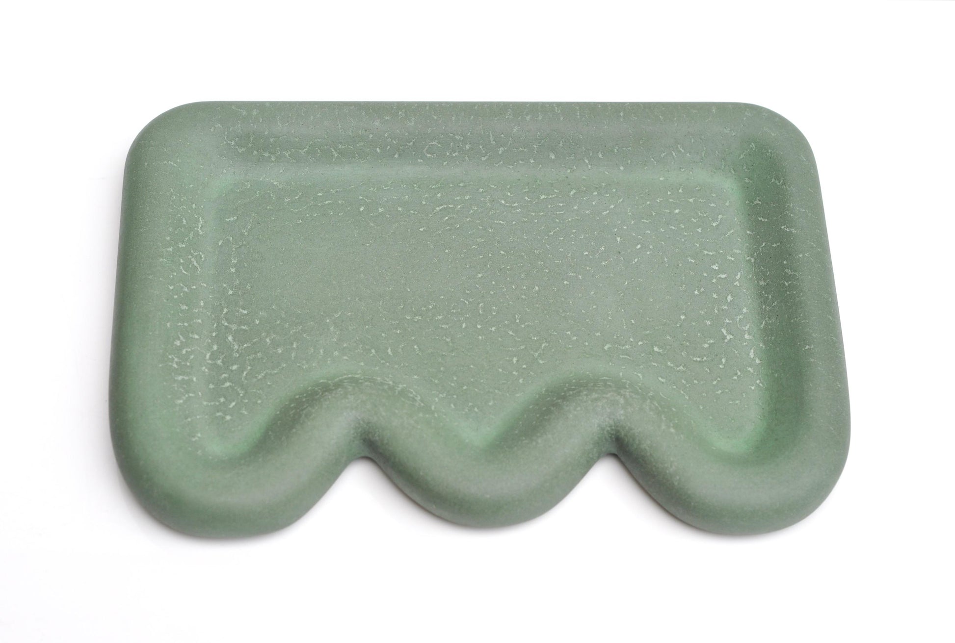 Green textured rectangular object on a white background