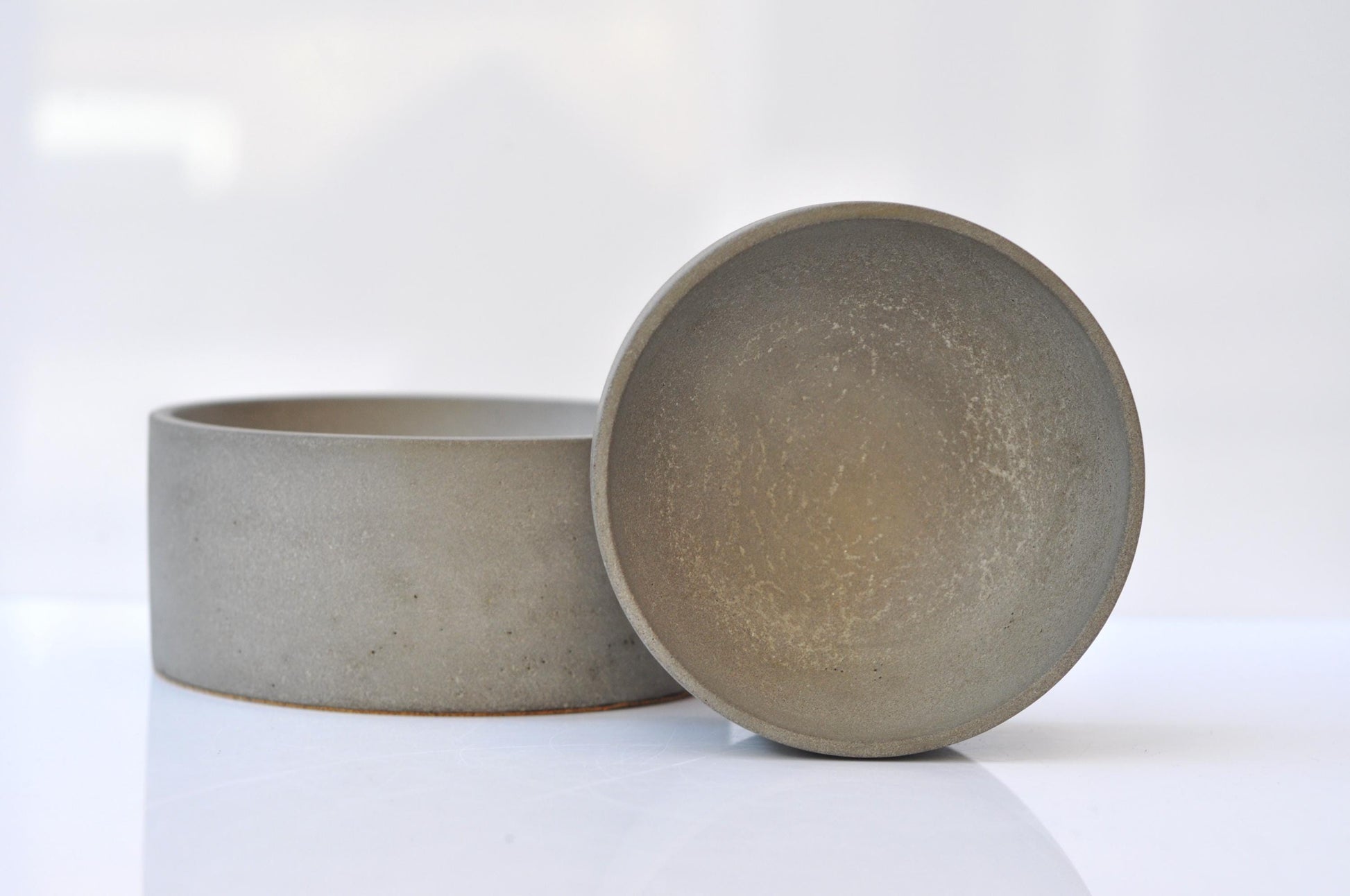 Two gray cement bowls on a white background
