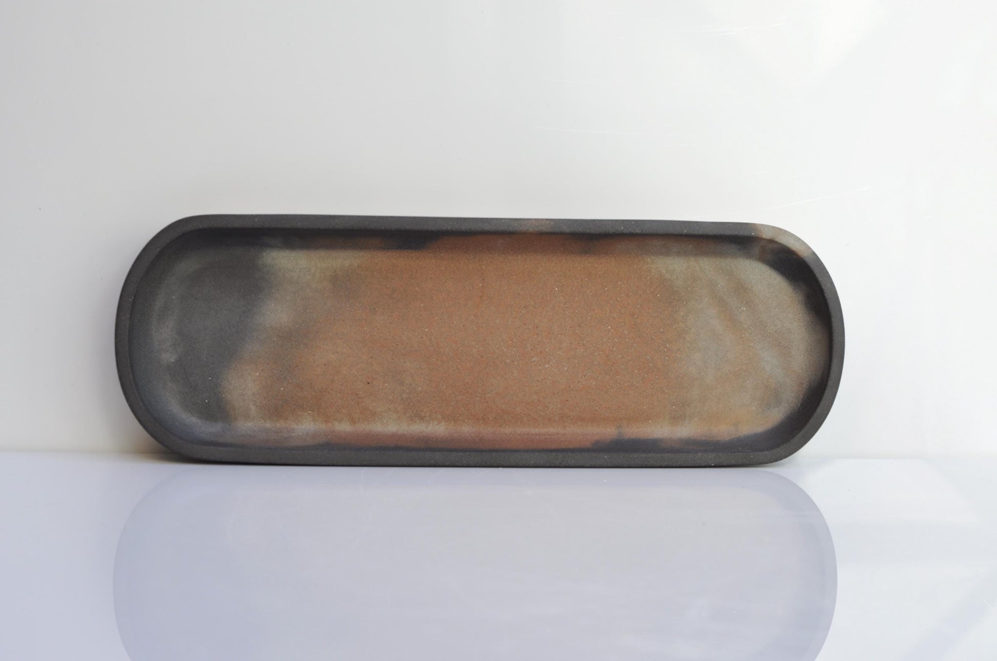 Side view of handmade long oval concrete dish