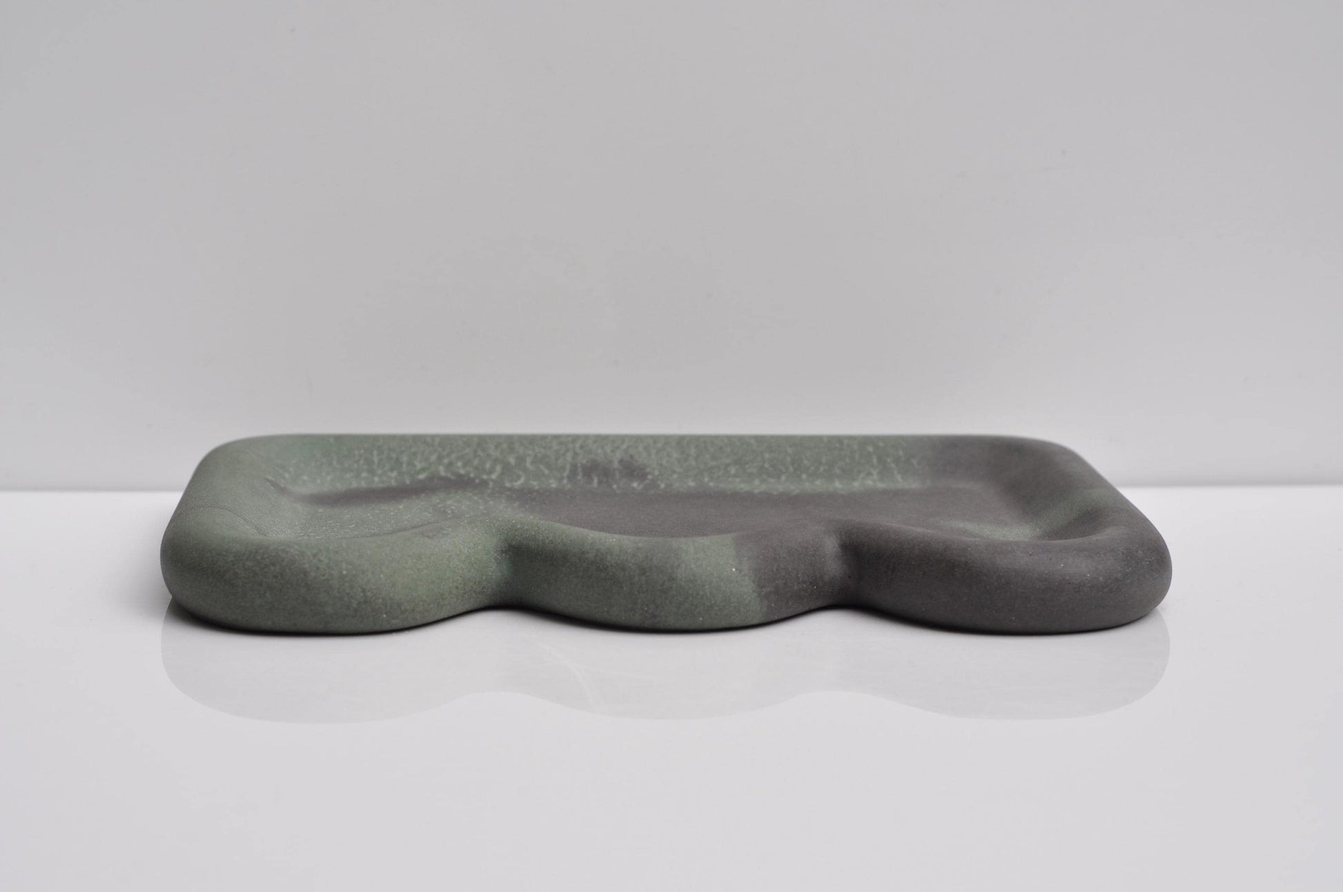 Studio shot of handmade dark grey-green concrete tray