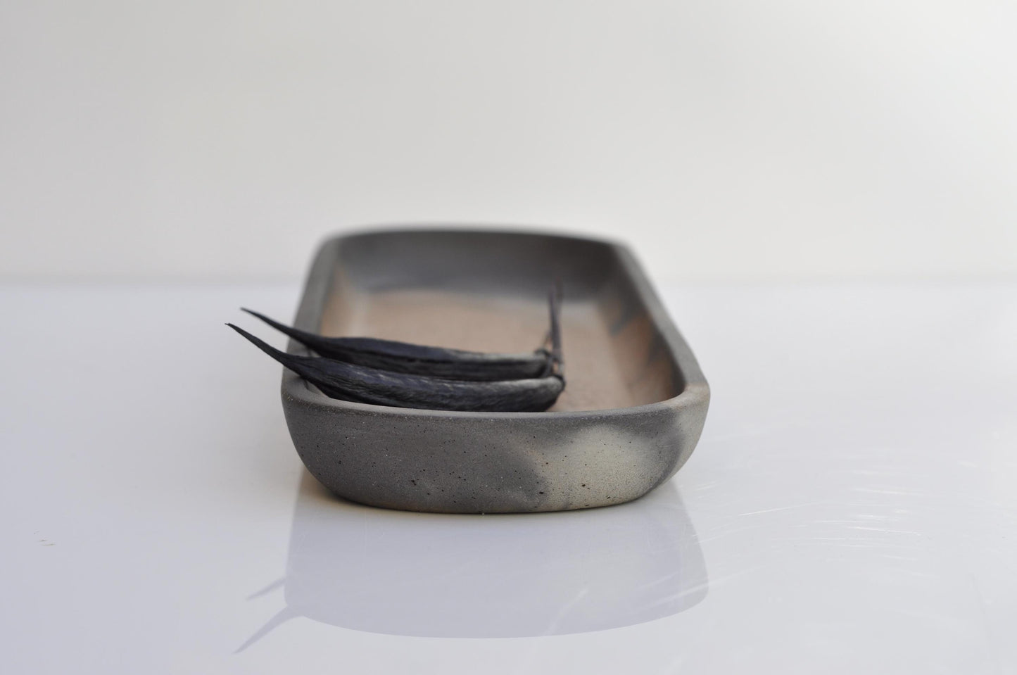 Side view of oval concrete tray showing shape and texture