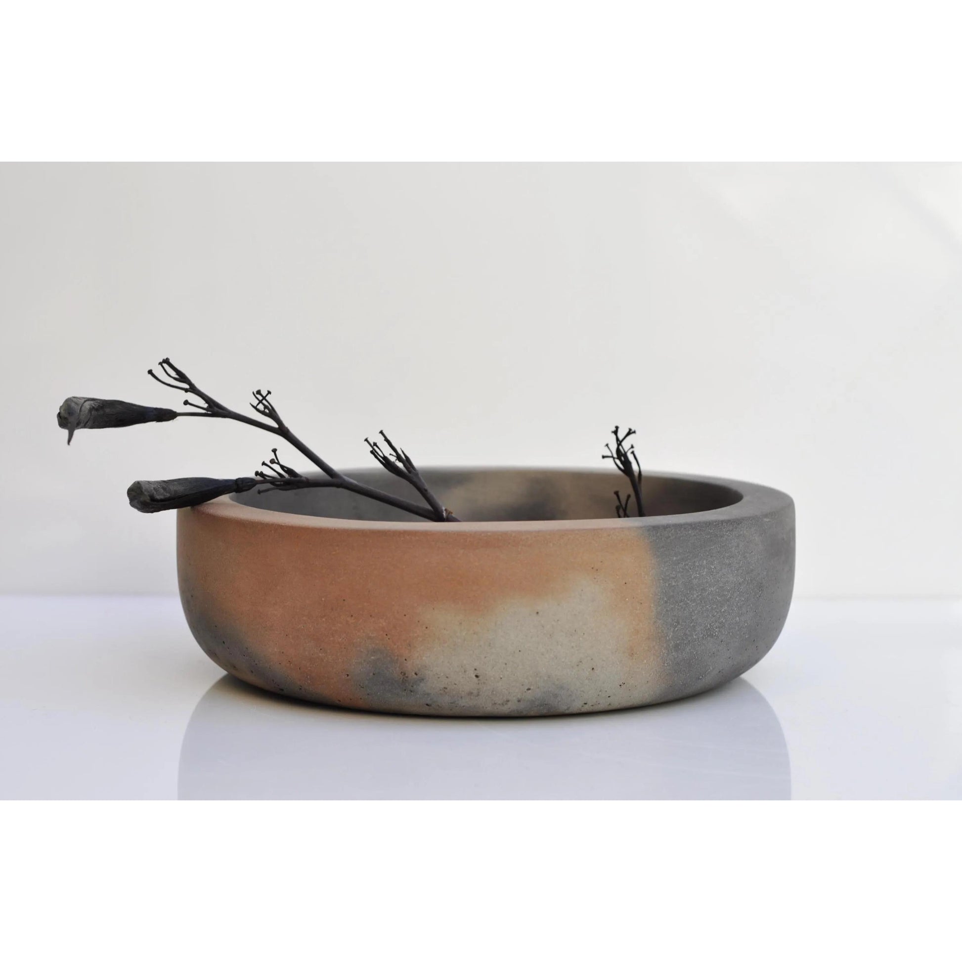 Large handmade cement bowl used as a decorative fruit dish