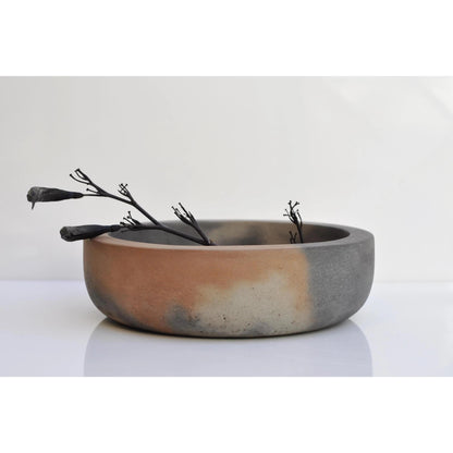 Large handmade cement bowl used as a decorative fruit dish