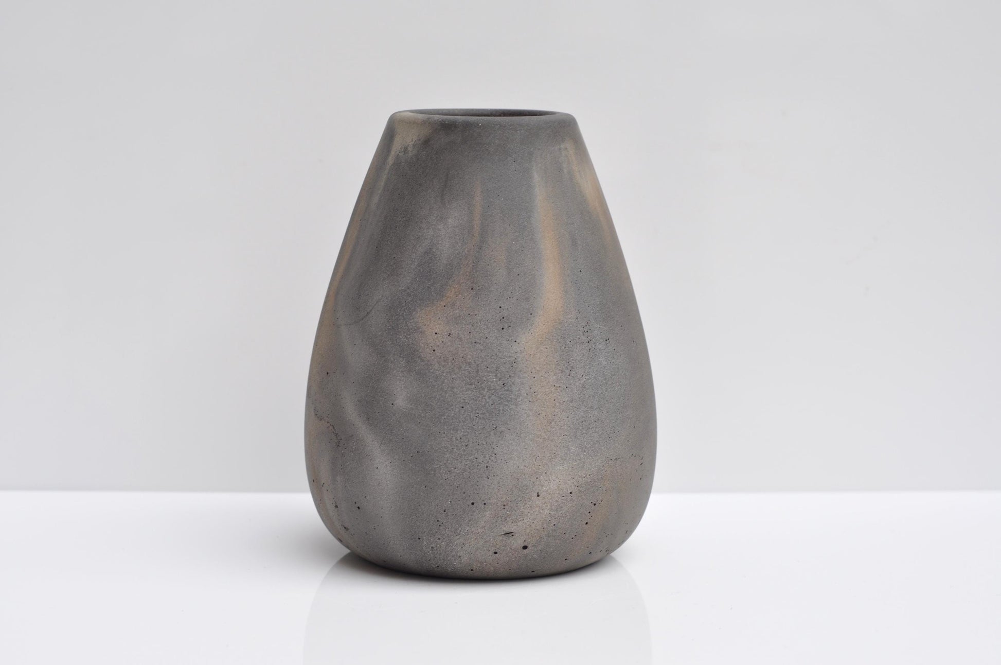 Studio shot of handmade grey and orange concrete vase