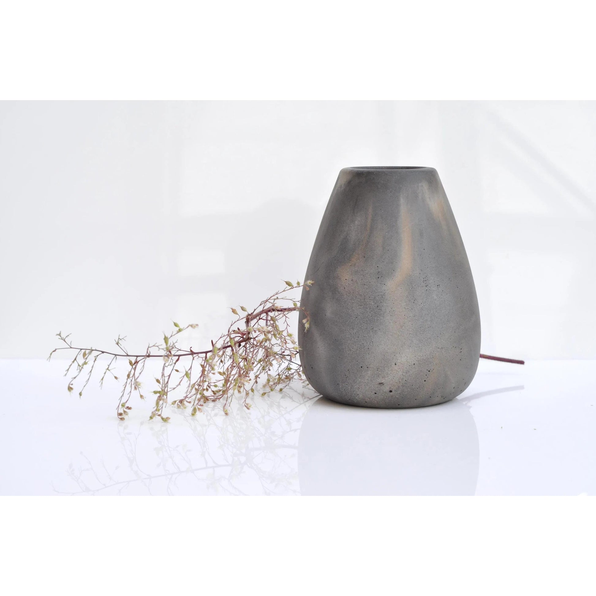 Gray ceramic vase with a branch on a white background