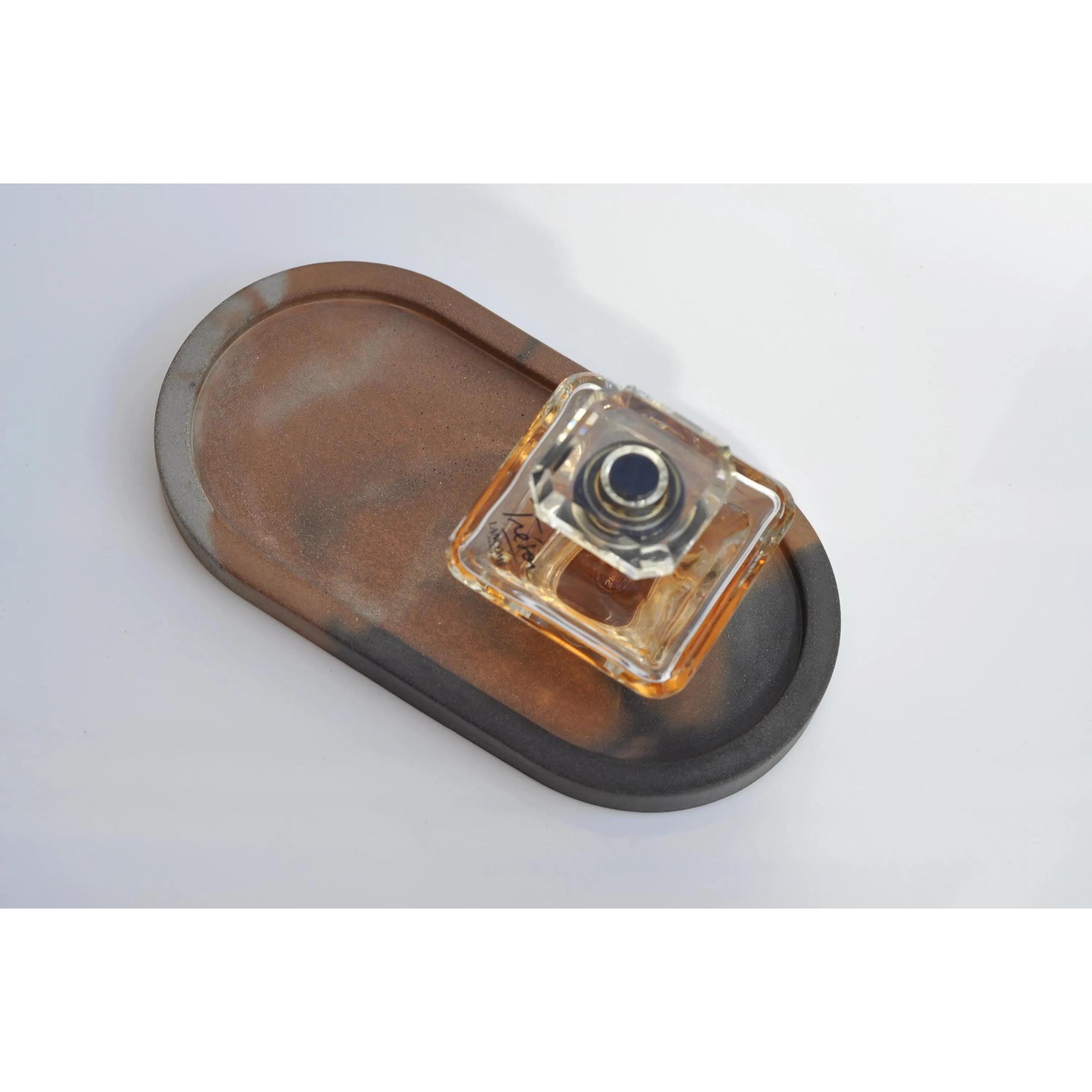 Handmade oval concrete tray used as a minimalist candle plate