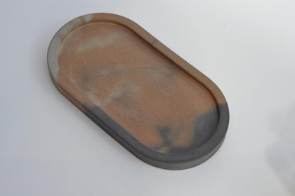 Oval concrete tray in minimalist grey, styled as a candle plate