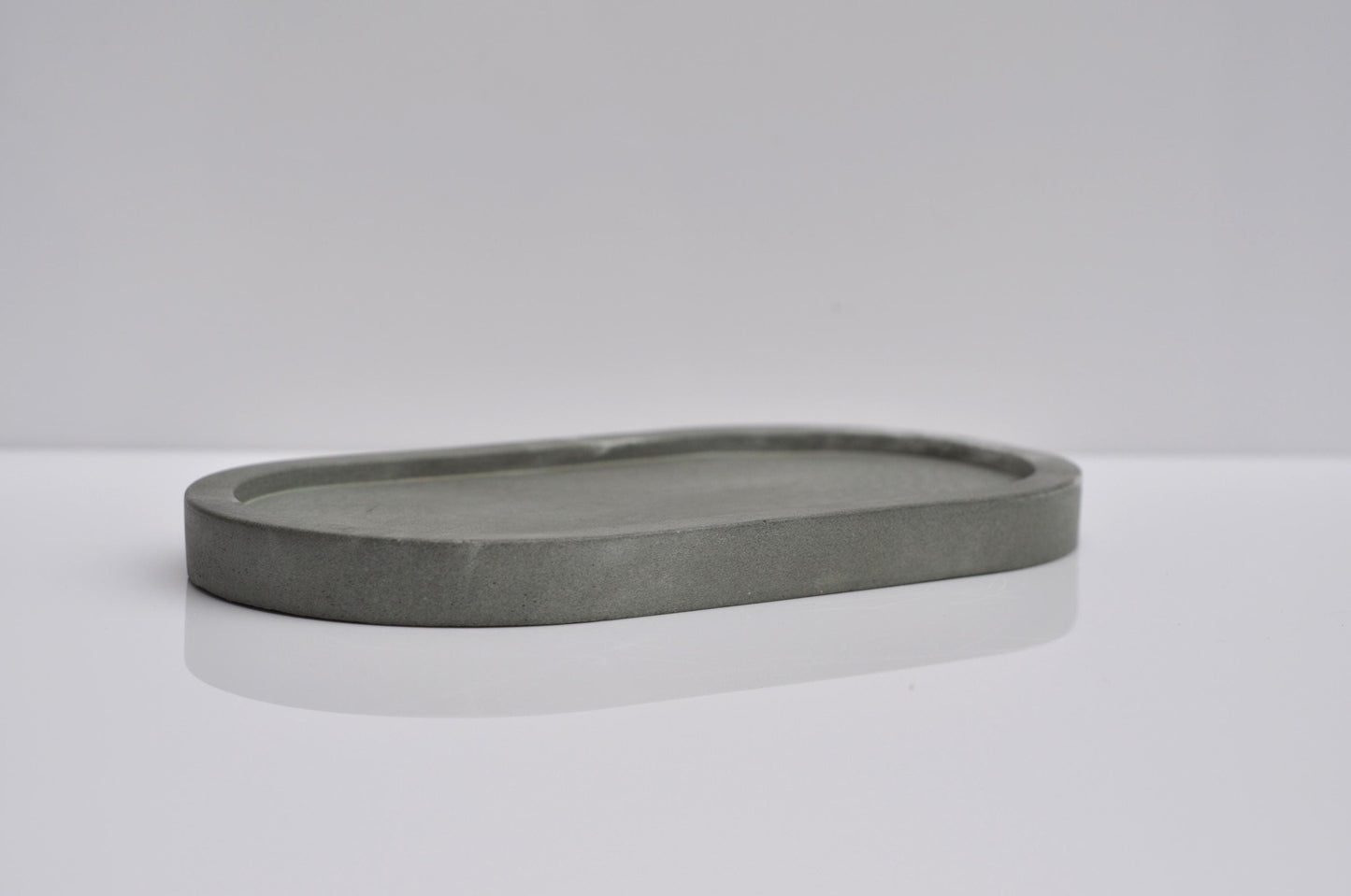 Gray stone tray on a white surface with a light gray background