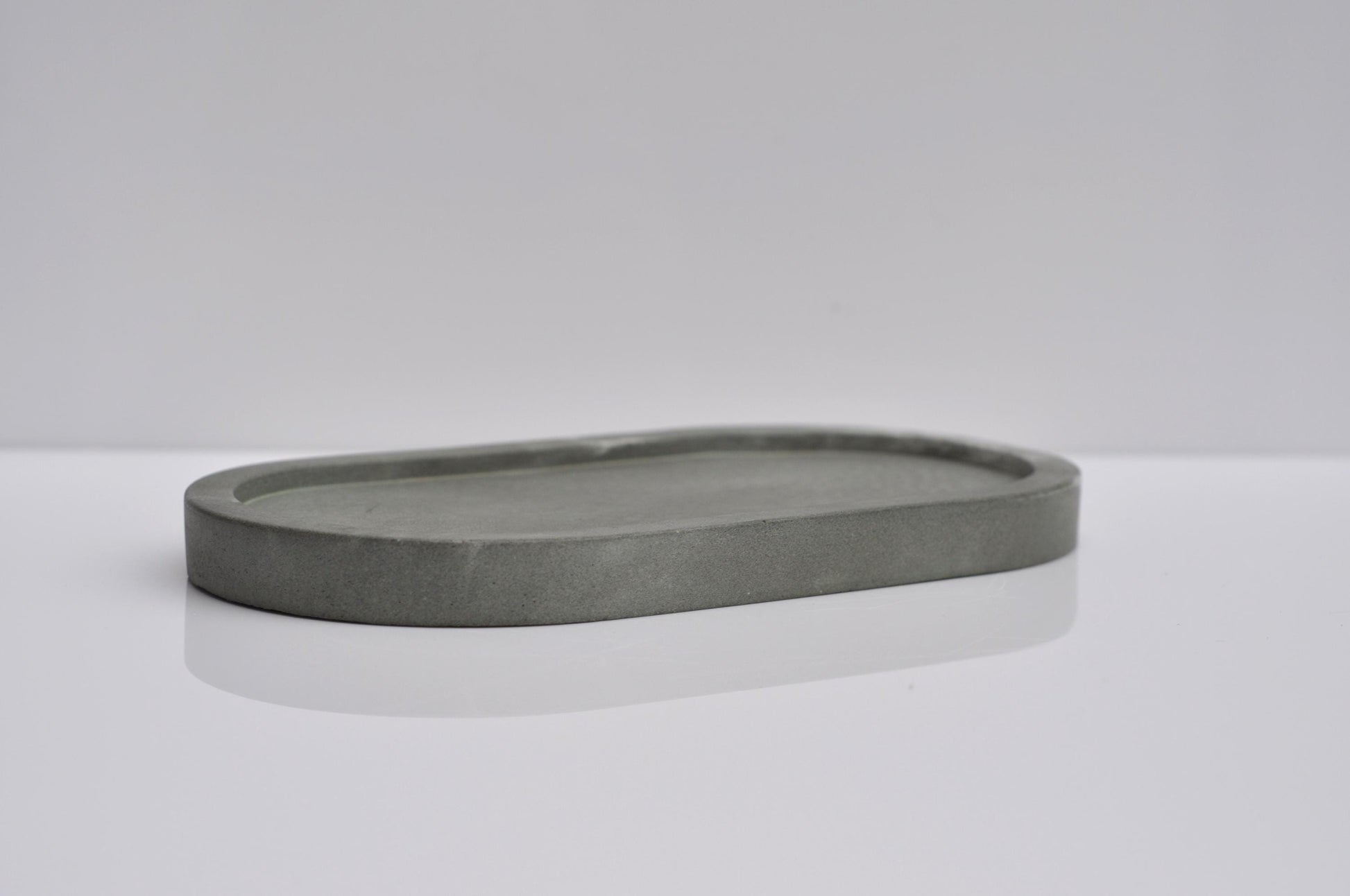 Gray stone tray on a white surface with a light gray background